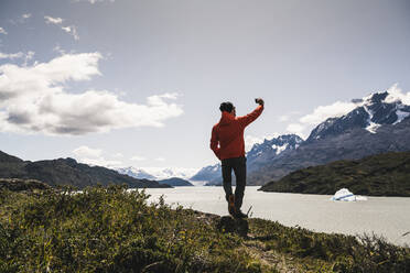 Mann, der ein Selfie macht, während er im Torres Del Paine Nationalpark steht, Patagonien, Chile, Südamerika - UUF20828