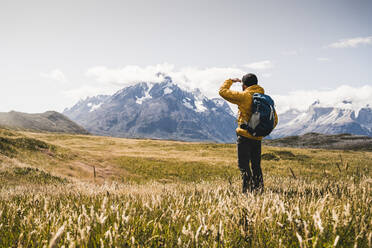 Man looking at view while exploring Torres Del Paine National Park in Patagonia, South America - UUF20834