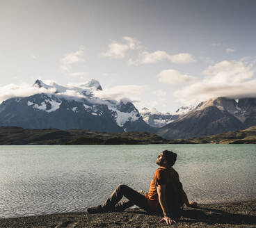 Mann beim Entspannen am Pehoe-See im Torres Del Paine-Nationalpark, Chile Patagonien, Südamerika - UUF20839