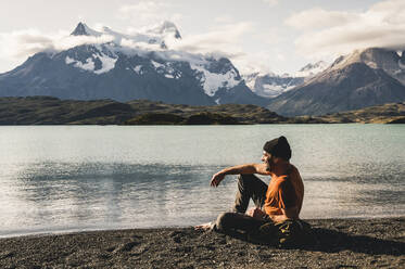 Mann sitzend am Pehoe-See im Torres Del Paine National Park, Chile Patagonien, Südamerika - UUF20841