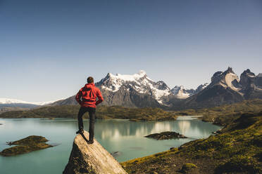 Mann steht auf einem Felsen am Pehoe-See im Torres Del Paine-Nationalpark, Chile Patagonien, Südamerika - UUF20857