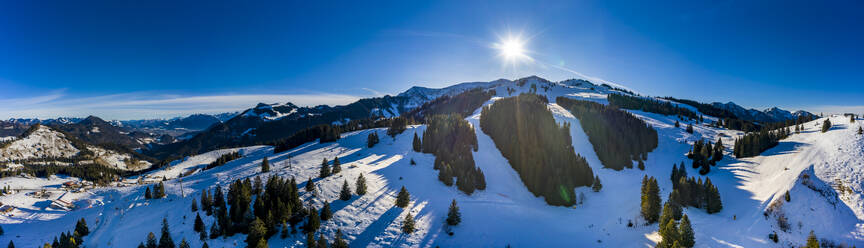 Hubschrauber-Panorama der Sonne über schneebedeckten Gipfeln im Mangfallgebirge - AMF08341