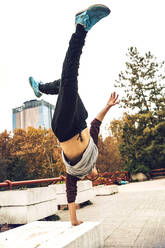 Junger Mann macht Handstand gegen den klaren Himmel - EHF00744