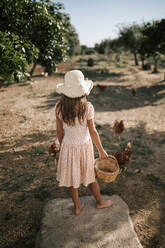 Mädchen mit Korb in Hühnerfarm stehend - GRCF00308