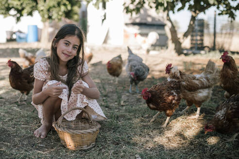 Mädchen mit Korb in Hühnerfarm sitzend - GRCF00312