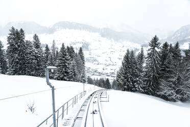 Switzerland, Canton of Saint Gallen, Railroad track stretching along snowcapped peak and valley of Chaserrugg mountain - TAMF02651