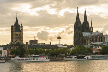 Deutschland, Nordrhein-Westfalen, Köln, Ausflugsboote vor der Großen Martinskirche und dem Kölner Dom in der Abenddämmerung - TAMF02653