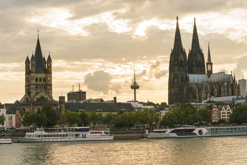 Deutschland, Nordrhein-Westfalen, Köln, Ausflugsboote vor der Großen Martinskirche und dem Kölner Dom in der Abenddämmerung - TAMF02653