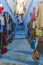 Kunsthandwerkliche Produkte an der Wand und auf den Stufen zum Verkauf in der Altstadt, Chefchaouen, Marokko - TAMF02675