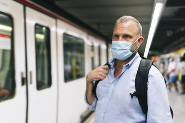 Businessman in protective face mask at subway station - DGOF01234