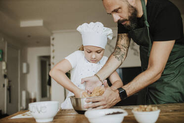 Vater und Tochter backen zu Hause Kekse - GMLF00430