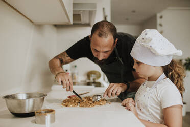 Vater und Tochter backen zu Hause Kekse - GMLF00434