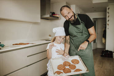 Vater und Tochter backen zu Hause Kekse - GMLF00436