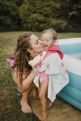 Mutter und glückliches Mädchen am aufblasbaren Schwimmbad im Garten - SMSF00130