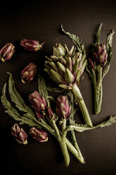 Fresh ripe artichokes placed on black background - ADSF09504