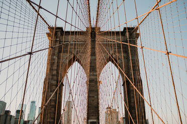 Perspective view of beautiful bridge gates with cables on background of New York city - ADSF09533