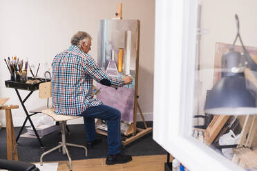 Älterer Mann malt Bild mit Pinsel - ADSF09594