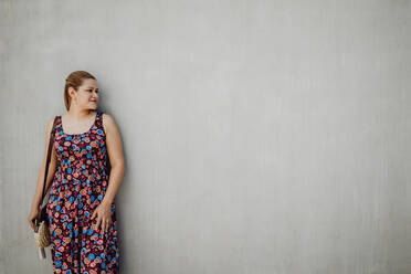 Young Women Wearing Summer Clothes Standing In Front Of A Wall. by Stocksy  Contributor BONNINSTUDIO  - Stocksy