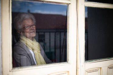 Ältere Frau schaut aus dem Fenster - ADSF09701