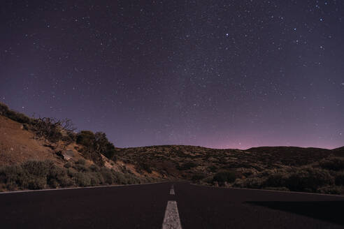 Malerische Ansicht einer Straße in der Wüste Spaniens vor einem atemberaubenden dunklen Himmel mit leuchtenden Sternen - ADSF09871