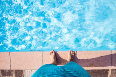 Nackte Füße eines Mannes, der am Rand eines Swimmingpools steht - MEUF01939