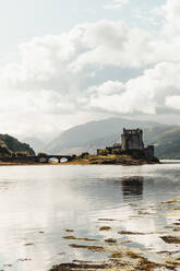 Wonderful scenery of abandoned medieval castle surrounded by river against foggy valley under blue sky with lush white clouds in Scotland - ADSF10112