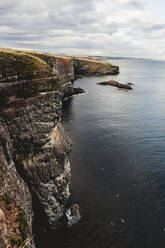 Rocky coast among tranquil ocean water in sunny day - ADSF10125