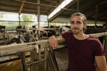 Porträt eines jungen Bauern im Kuhstall auf einem Bauernhof - KNSF08287