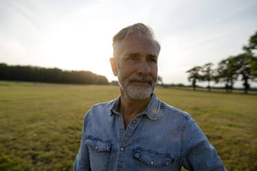 Content mature man on a meadow in the countryside - KNSF08289