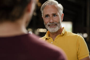 Portrait of mature man talking to young man - KNSF08325