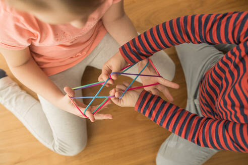 Schlaue Kinder benutzen Gummibänder zum Spielen - ADSF10166