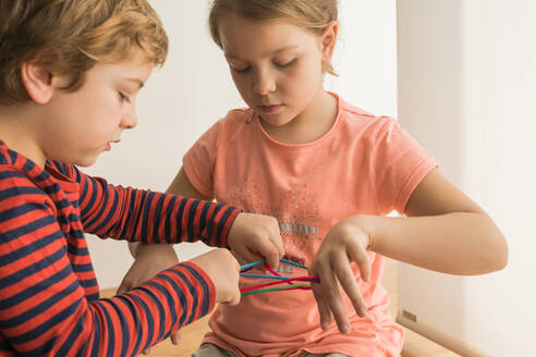 Schlaue Kinder benutzen Gummibänder zum Spielen - ADSF10167