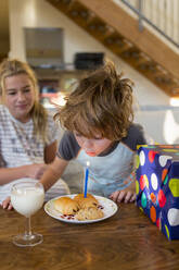 5 Jahre alter Junge bläst Kerze auf Croissant aus - MINF15006