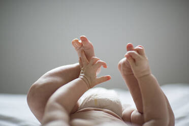 Beine und Hände des auf dem Rücken liegenden Babys - MINF15030