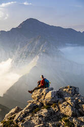 Mann auf dem Gipfel eines Berges in den Bergamasker Alpen, Italien - MCVF00561