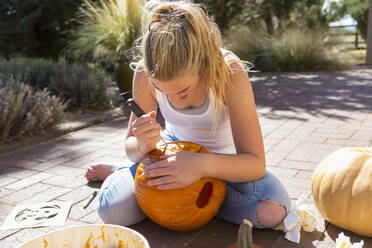 11 year old girl carving a pumpkin - MINF15044