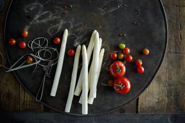 Tomaten und geschälte Spargelstangen auf rustikalem Backblech - ASF06661