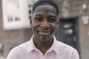 Smiling man standing in city - KMKF01440