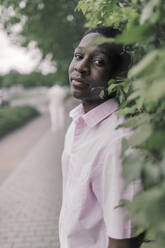 Man standing by plants in city - KMKF01444