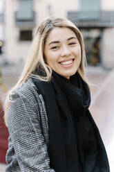 Young smiling woman looking at camera in city - RDGF00017