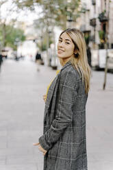 Young woman looking at camera in city - RDGF00020