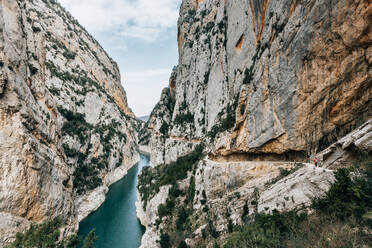 Spektakuläre Szenerie eines ruhigen, schmalen Flusses mit grünem Wasser, der zwischen rauen Felsen im Montsec-Gebirge in Spanien fließt - ADSF10447