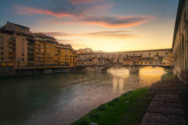 City bridge with buildings above river in sunset light, Florence, Italy - ADSF10504