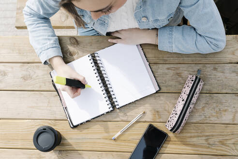 Student mit Filzstift und Buch am Tisch - RDGF00042