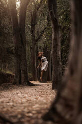 Mysteriöse ruhige Frau in weißem Kleid springt schwebend in ruhigen herbstlichen Park - ADSF10681