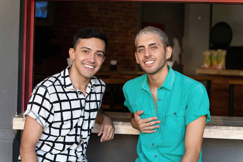 Friends smiling while sitting at bar counter of restaurant - SPCF00829