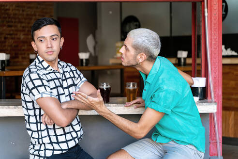 Gay couple arguing while sitting at bar counter - SPCF00840