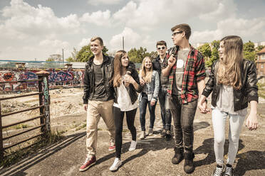 Group of friends hanging out in an old run down industrial area - DHEF00210