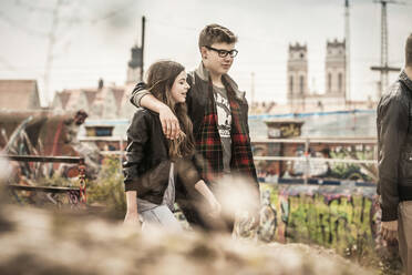 Cooles Teenager-Paar, das in einem alten, heruntergekommenen Industriegebiet spazieren geht - DHEF00212