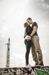 Küssendes Teenager-Paar auf einer Graffiti-Wand - DHEF00225